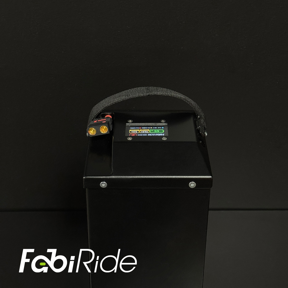 Juodas elektrinis krosinis motociklas su geltonais akcentais žalios sienos fone.