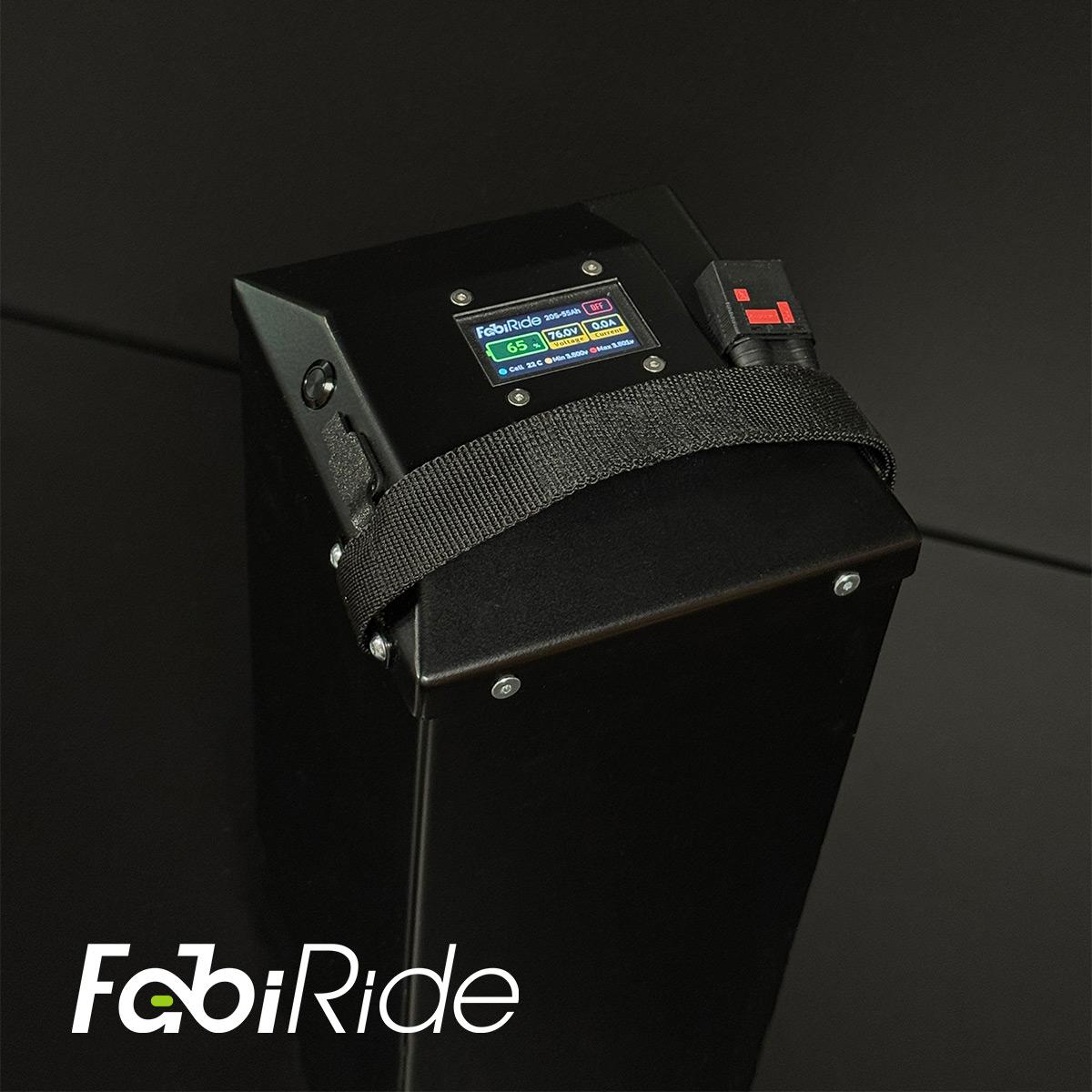 Juodas elektrinis krosinis motociklas su geltonais akcentais žalios sienos fone.